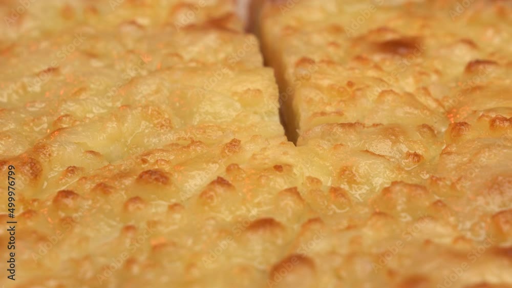 Male hand cutting with a knife khachapuri lying on a wooden board closeup. Megrelian khachapuri traditional georgian dish. High quality 4k footage Male hand cutting with a knife khachapuri lying on a wooden board closeup. Megrelian khachapuri traditional georgian dish. High quality 4k footage