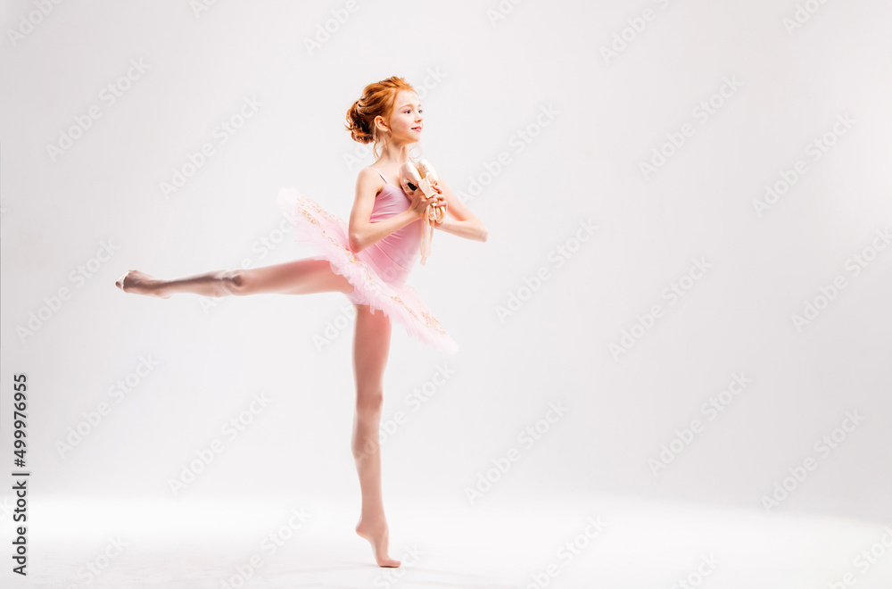 Little ballerina dancer in a pink tutu academy student posing on a white background Little ballerina dancer in a pink tutu academy student posing on a white background