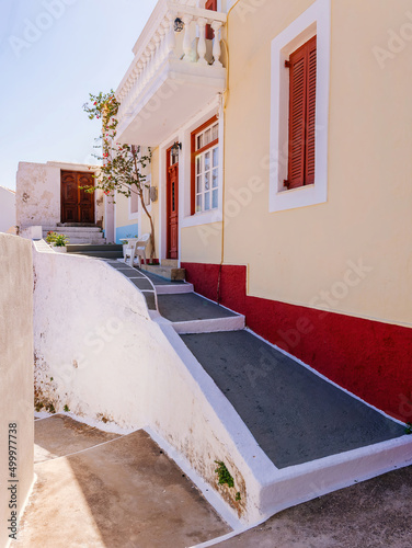 Narrow streets that go up and down pass in front of colored houses under the crystal clear blue sky. .Aperi, Karpathos island, Greece. photo