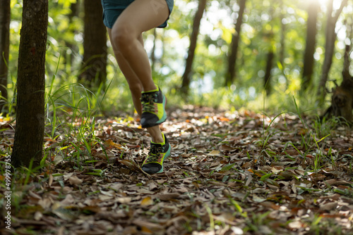 Woman runner running on forest trail