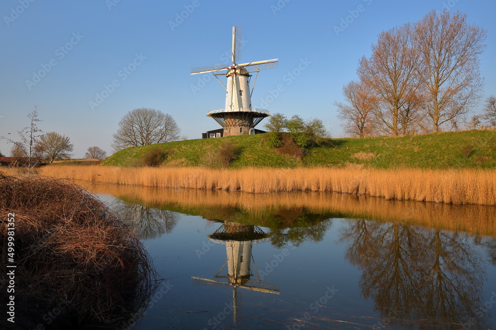 Reflections of a traditional windmill in the colorful countryside surrounding Veere, Zeeland, Netherlands