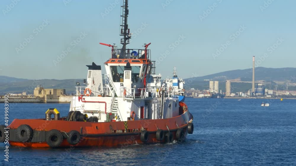 A tugboat, the 'Eliott' in Gibraltar harbour. Passing left to right. Sunshine A tugboat, the 'Eliott' in Gibraltar harbour. Passing left to right. Sunshine