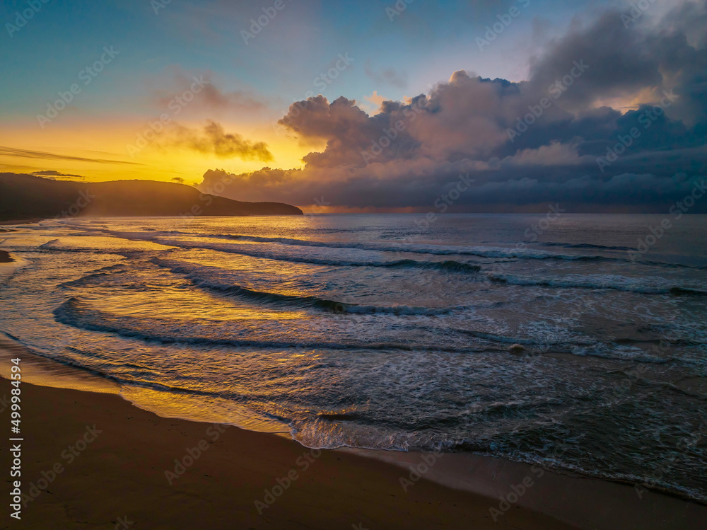 Obraz premium Sunrise seascape with rain clouds on the horizon