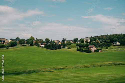 Eine Landschaft mit Mittelsachsen mit grüner Wiese und kleinen Dörfern