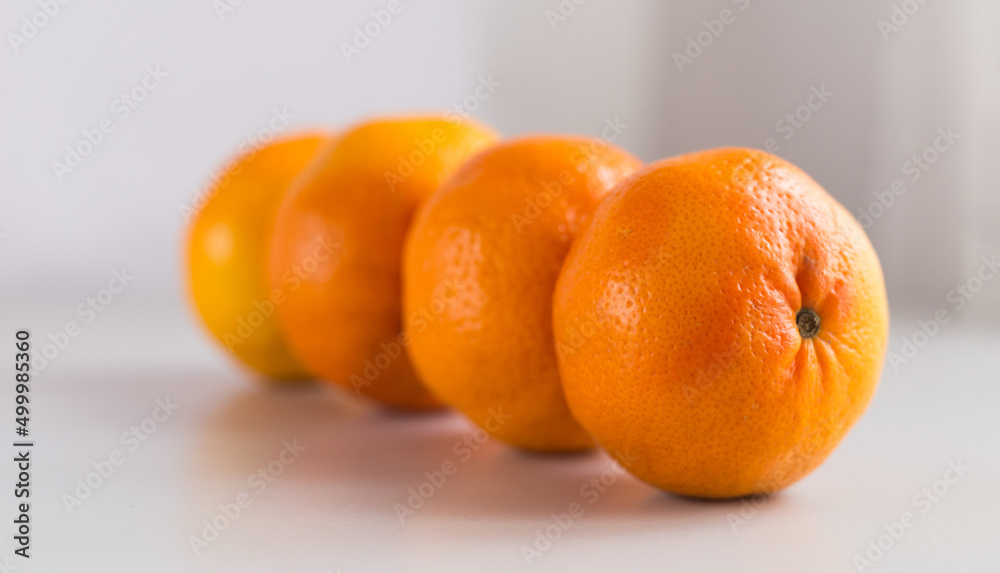 appetizing tangerines laid out in a row on white background