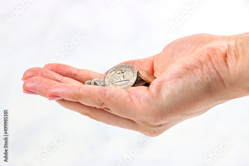 Usa coins in Caucasian woman hands on light background. Money, tips and savings concept.