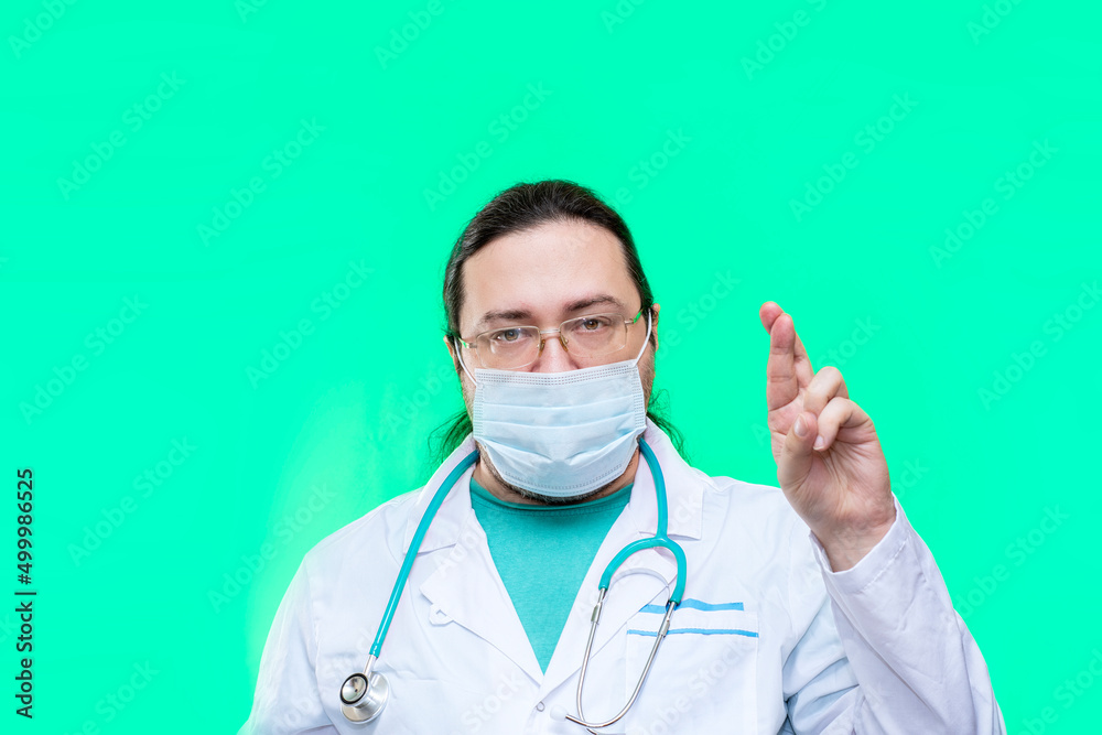 An adult, medical doctor holds his fingers crossed in front. An adult, medical doctor holds his fingers crossed in front.