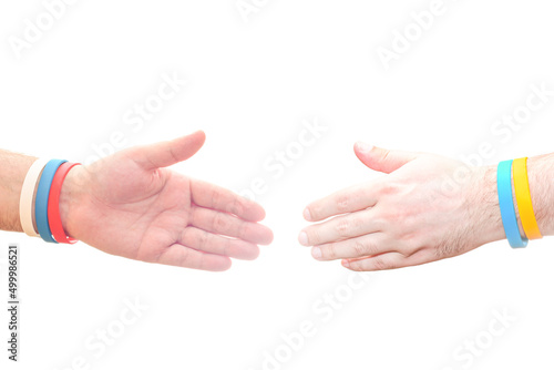 Two hands on a white background outstretched for a handshake. Template with empty place for text on the topics of consent and agreement. Bracelets in the colors of the Russian and Ukrainian flags.