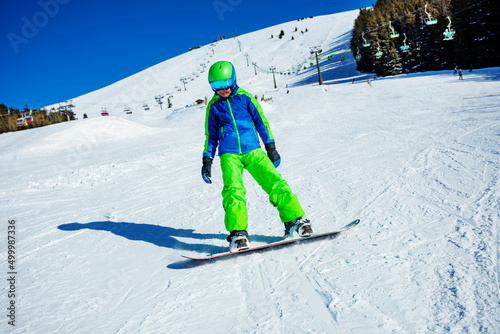 Action photo of a snowboarder boy in motion on ski slope