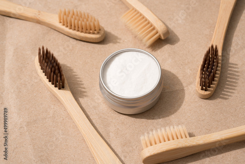 Natural wooden bamboo toothbrushes with natural bristle and mineral toothpowder on kraft paper background. Natural bath products  organic dentifrice. Mockup image  top view