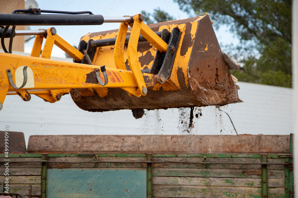 Fototapeta premium Mechanical shovel emptying the debris onto the trailer.