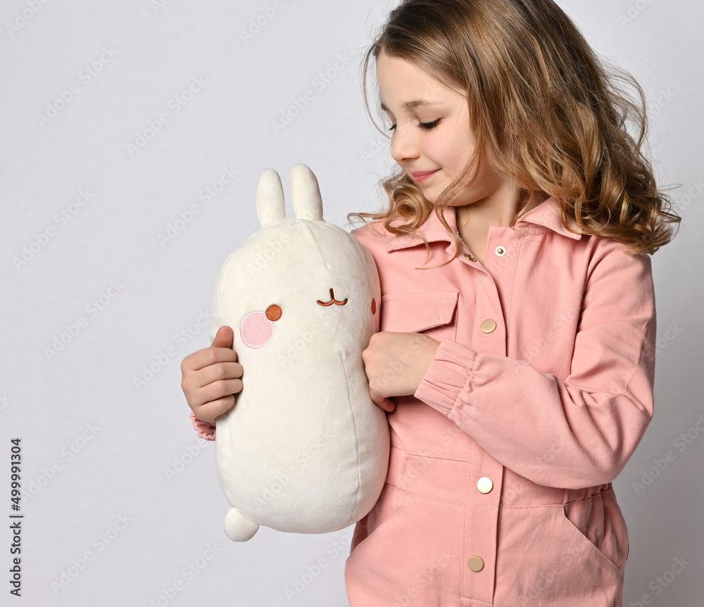 Girl hugs a plush toy on a light background Girl hugs a plush toy on a light background