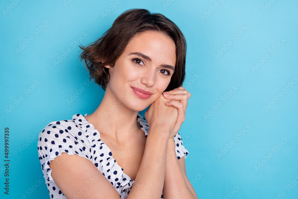 Portrait of gorgeous positive lady arms palms folded look camera isolated on blue color background
