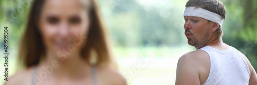 Fotografie, Tablou Young man looks at beautiful girl jogging closeup