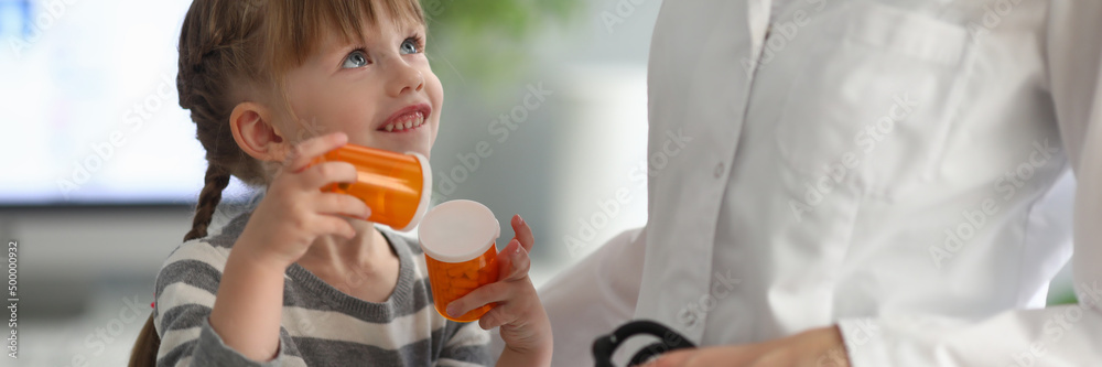 Little girl holding pills at pediatrician appointment Little girl holding pills at pediatrician appointment