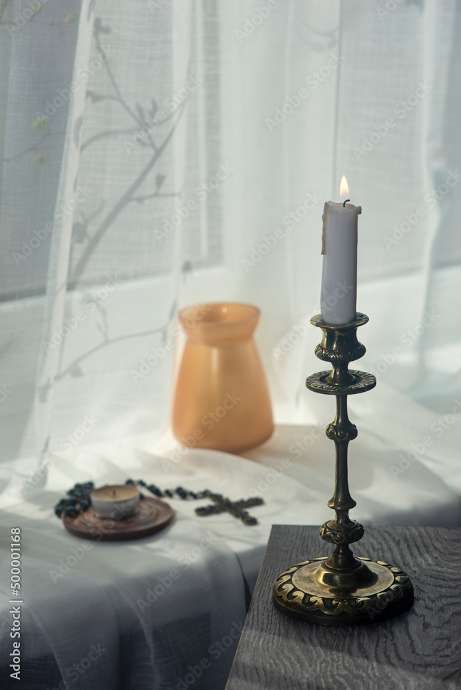 Composition of objects on the windowsill.Vases on the windowsill create a mood.Cross, lamp, shadow drawing from the window. Composition of objects on the windowsill.Vases on the windowsill create a mood.Cross, lamp, shadow drawing from the window.