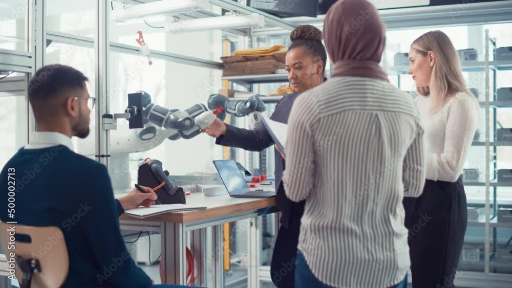 Black Senior Engineer Explaining Information to People Look at Robot Limb. People Hold Devices and Discussing. Optimisation of Autonomous Manufacturing Facility that Creates Great Products Concept Black Senior Engineer Explaining Information to People Look at Robot Limb. People Hold Devices and Discussing. Optimisation of Autonomous Manufacturing Facility that Creates Great Products Concept