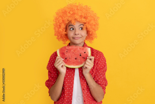fancy teen girl having fun. summertime. face of child with orange hair hold water melon slice