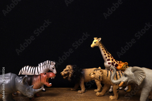 Fototapeta Naklejka Na Ścianę i Meble -  Group of jungle animals toys isolated over black background. Plastic animals toys. Protection of the animal. Children's toy.