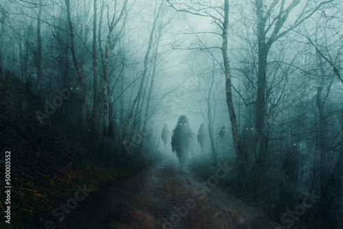 A horror concept of cute floating ghost monsters on a forest road. On a spooky foggy winters evening. With a grunge, texture edit.