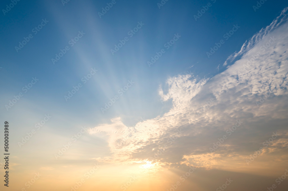 sunset / sun rise sky with rays of light shining clouds and sky background and texture