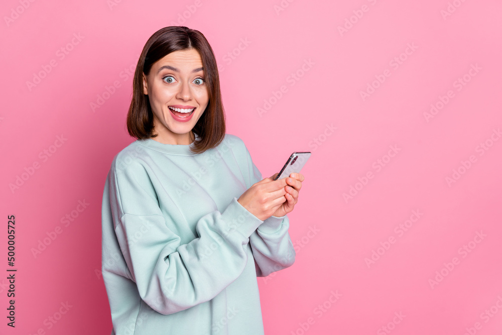 Photo of impressed bob hairdo young lady hold telephone wear blue hoodie isolated on pink color background Photo of impressed bob hairdo young lady hold telephone wear blue hoodie isolated on pink color background