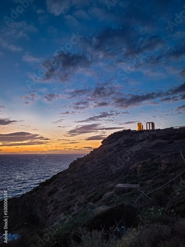 Beautiful sunset over the cliff of The Temple of Poseidon at Cape Sounion, over the Aegean Sea Greece