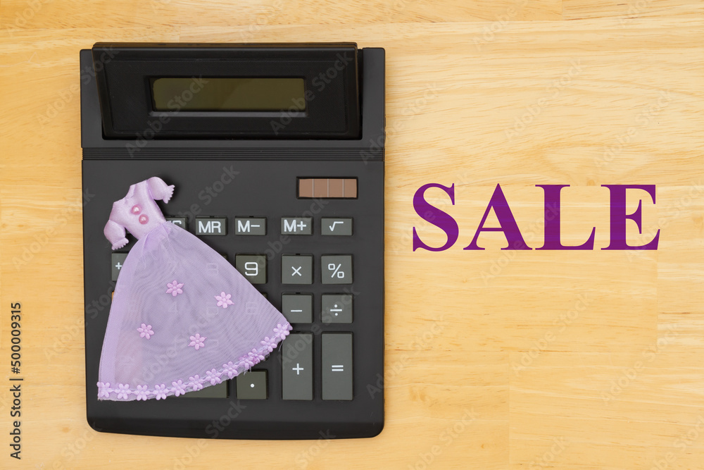 Sale message with a calculator and a fancy purple dress Stock