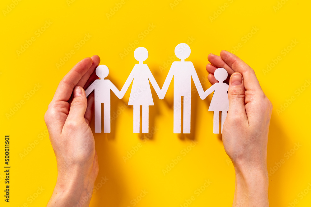 Care of family concept. Wooden figures in hand Care of family concept. Wooden figures in hand