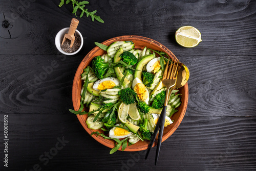 Ketogenic, paleo diet lunch bowl with avocado, cucumber, broccoli and egg. Healthy organic vegan salad. Delicious breakfast or snack, Clean eating, dieting, vegan food concept. top view