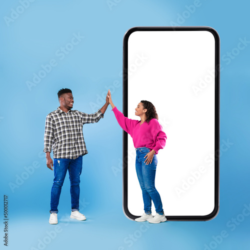 African Couple Near Phone Giving High Five Over Blue Background