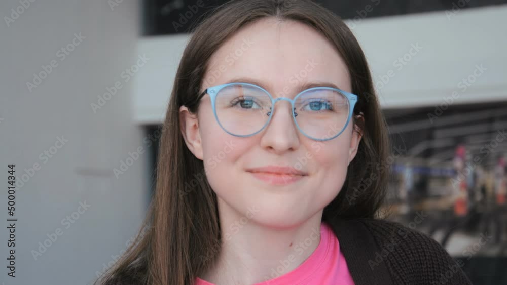 Beautiful young caucasian girl in glasses portrait looking at the camera and smiling indoors