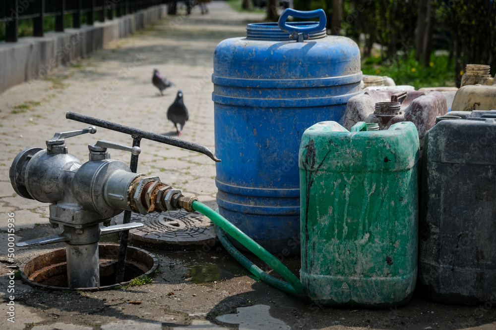 Water hydrant and some big plastic barrels Water hydrant and some big plastic barrels