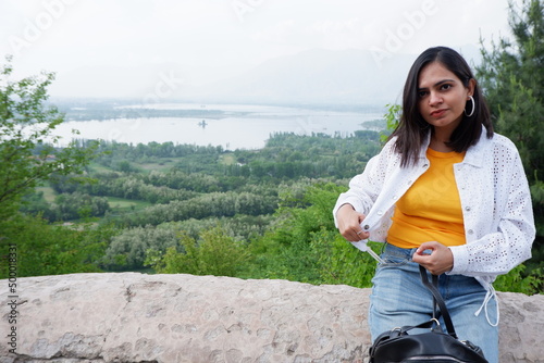 Beautiful girl sitting and enjoying the view of lansdscape dal lake from pari mahal top. photo