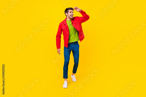 Full length photo of funky brunet millennial guy go look promo wear shirt pants footwear isolated on yellow background