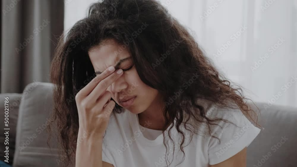 Tired African American woman take off glasses suffer from migraine or headache at home. Exhausted young biracial female feel unhealthy massage eyes struggle with blurry vision or dizziness. Tired African American woman take off glasses suffer from migraine or headache at home. Exhausted young biracial female feel unhealthy massage eyes struggle with blurry vision or dizziness.