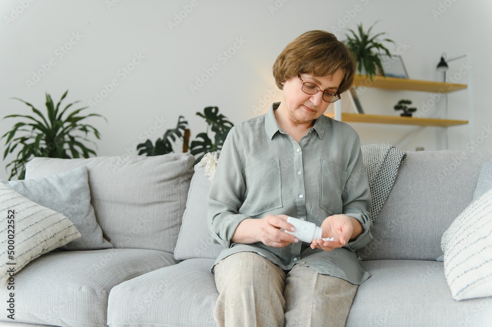 age, medicine, healthcare and people concept - senior woman with glass of water taking pills at home age, medicine, healthcare and people concept - senior woman with glass of water taking pills at home