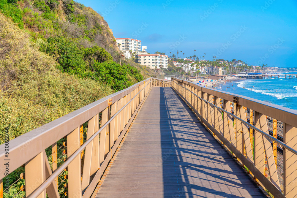 Narrow bridge with yellow railings near the mountain slope at the coastal area of San Clemente, CA