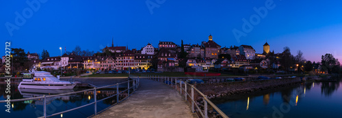Murten, Switzerland - March 24.2022: Blue hour townscape panorama of medieval Murten or Morat, a bilingual municipality in the lake district of the canton of Fribourg.