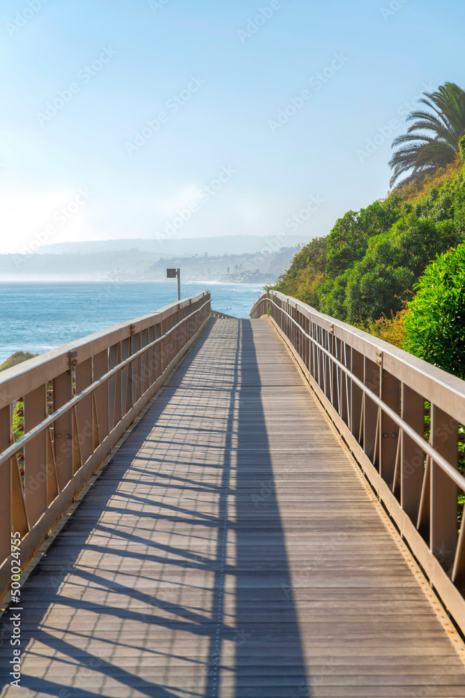 Straight narrow bridge with a view of the blue sea water against the sky in San Clemente, California