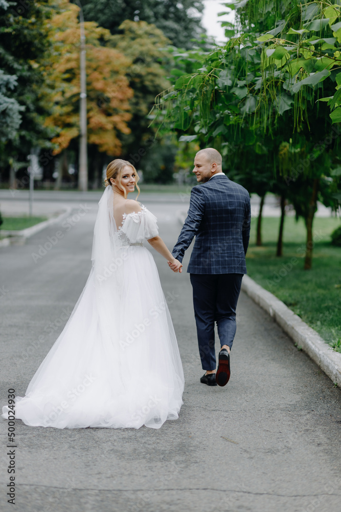  Couple walking outdoors. Classic style, white dress.