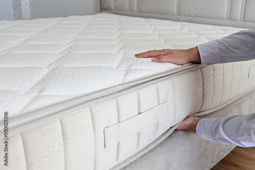 Fotografie Cropped shot of man testing white orthopedic matress on firmness