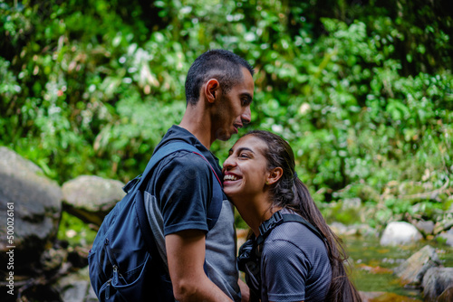 young latin couple in love in the jungle laughing in tranquility with nature