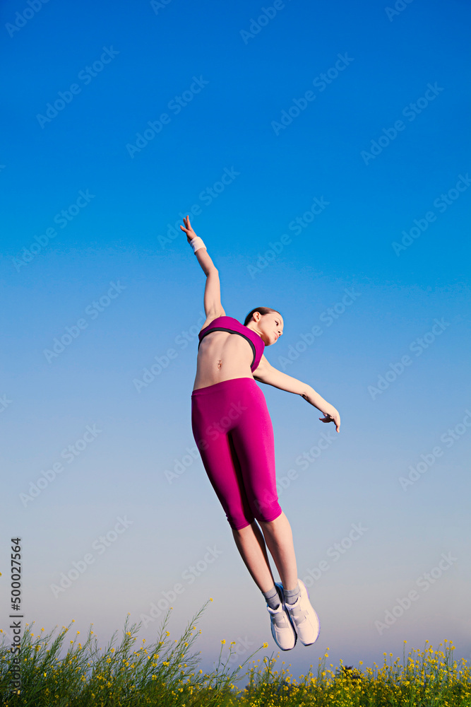 Beautiful young woman jumping in the farm