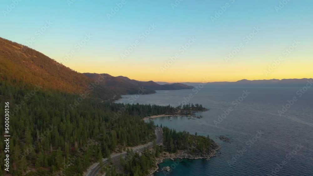 Panning Left Across Sun Setting Over Mountains in Scenic Lake Tahoe with Pine Tree Forest and Clear Blue Water - Aerial Drone Shot Panning Left Across Sun Setting Over Mountains in Scenic Lake Tahoe with Pine Tree Forest and Clear Blue Water - Aerial Drone Shot