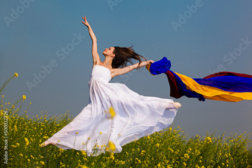 Beautiful young woman jumping in the farm photo