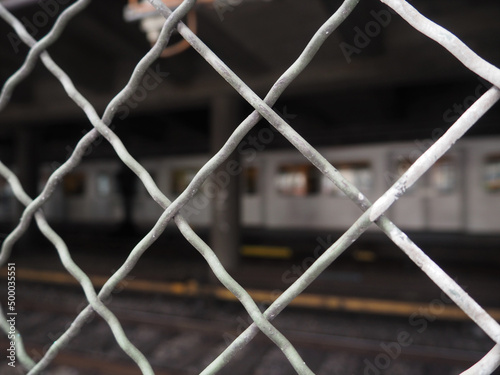 Canvas Print Fence with bokeh of subway passing by