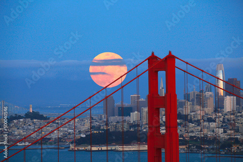 Fototapeta Famous Golden Gate Bridge with buildings in the background in San Francisco, Cal