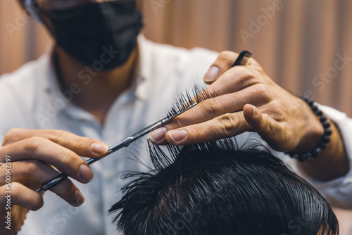 Barber styling hair of his client