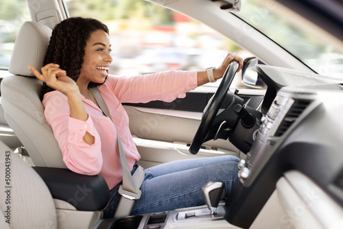 Foto Happy black woman enjoying music driving luxury car